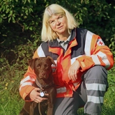 Rettungshundeteam beim Fotoshooting auf einer Wiese