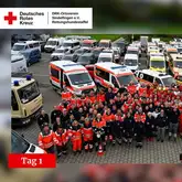 Parkpplatz mit vielen Einsatzfahrzeugen und Einsatzkräften der Rettungshunde, Feuerwehr und Sanitätern