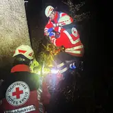 Einsatzkräfte versorgen Nacht im Wald eine verletzte Person mit einer Wärmeschutzdecke