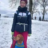 Person mit Hund zwischen den Beinen im SChnee