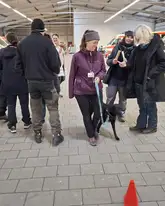 Menschengruppe um ein engehenden Therapiehund  in einer Halle
