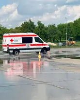 Einsatzfahrzeug des DRK Reutlingen der Rettungshunde fährt beim Fahrsicherheitstraining über eine Nasse Fahrbahn