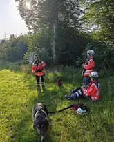 Einsatzkräfte der Rettungshunde DRK der Schwäbischen Alb machen eine Pause im Grün auf einer Wiese