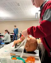 Person befestigt I-Gel bei Puppe