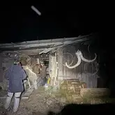 alter Schuppen bei Nacht mit Personen