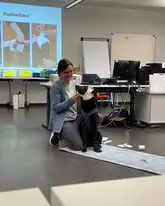 Hund wird ein Kopfverband bei einer erste hilfe am hund fortbildung in einem Vorlesungssaal angelegt