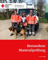 Rettungshundeteam Mantrail mit Urkunde und Prüfern vom DRK vor einem Einsatzfahrzeug
