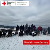 Personengruppe mit Hunden im Schnee bei Gruppenbild