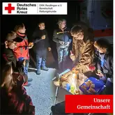 Gemeinschaft steht im Kreis mit einem Campingtisch mit Verpflegung und essen gemeinsam