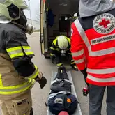 Einsatzkräfte mit Atemschutzmaske mit Trage